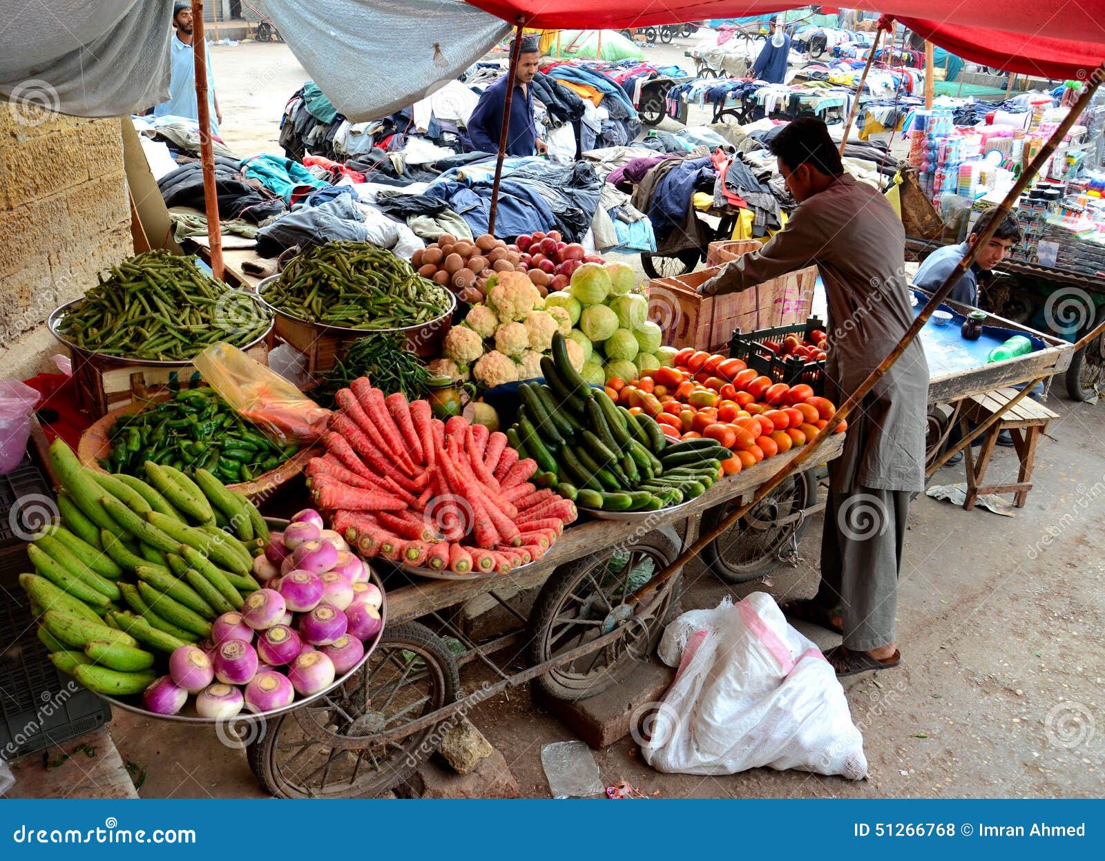 fruit-vegetable-seller-tends-to-his-cart-outside-empress-market-karachi-pakistan-february-man-unpacks-fruits-vegetables-add-51266768.jpg