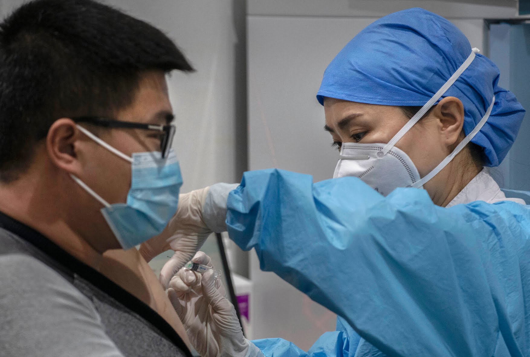 A Chinese health care worker giving a Covid-19 vaccine in Beijing. Confusion about what “efficacy” trials really measure and mean has created doubt about vaccines — and about some vaccines more than others.