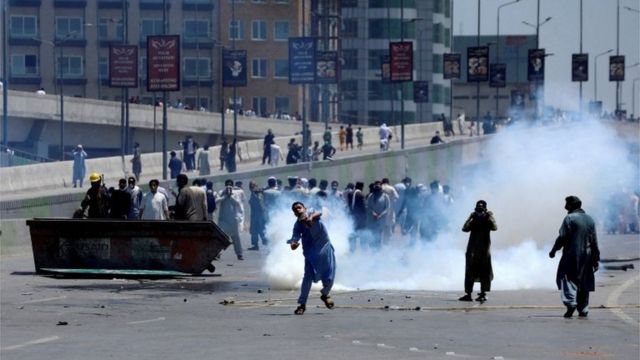 People throw stones at police during a protest against former Prime Minister Imran Khans arrest, in Peshawar, Pakistan, May 10, 2023.