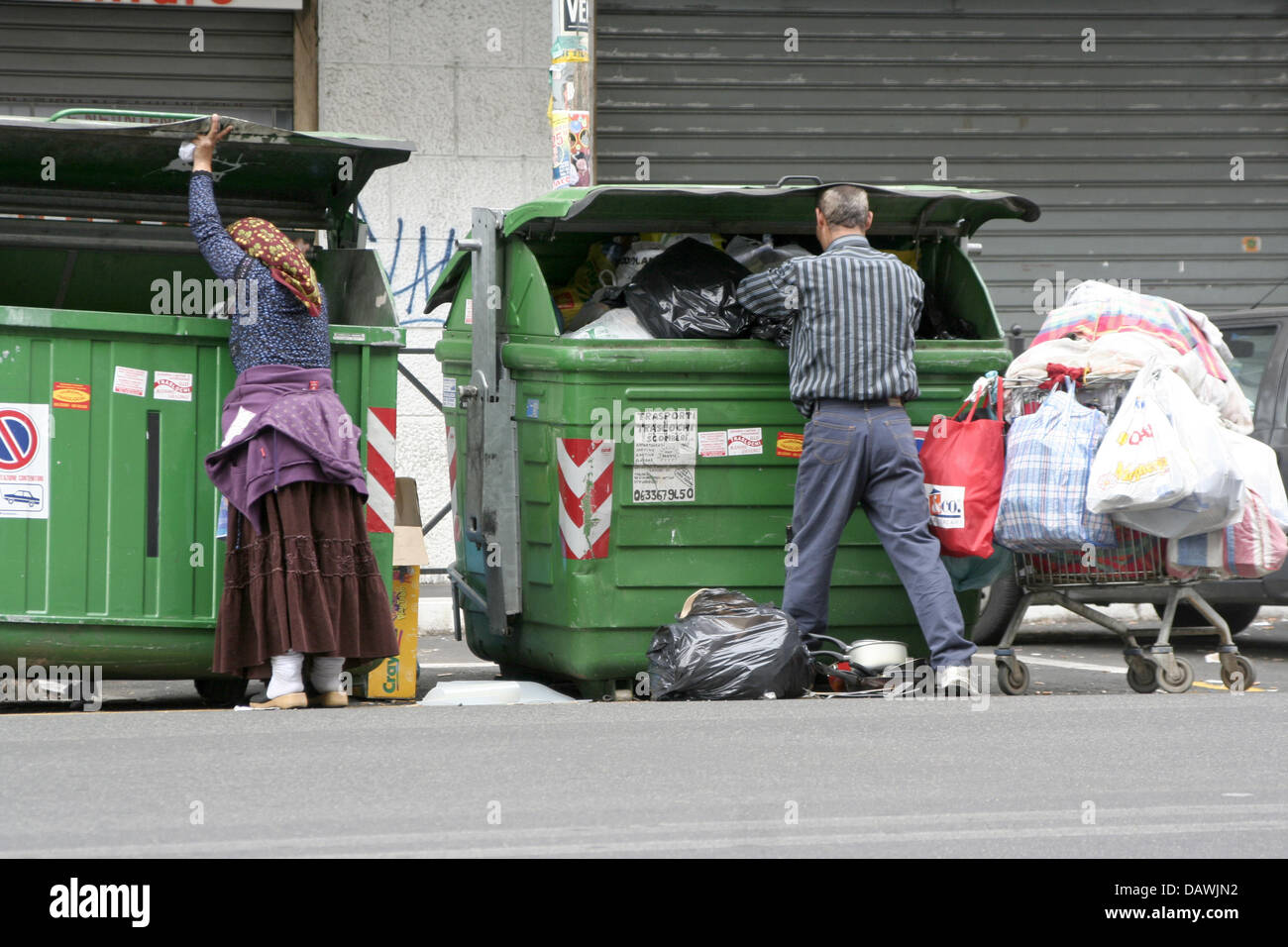 a-man-and-a-woman-rummage-through-rubbish-containers-in-rome-italy-DAWJN2.jpg