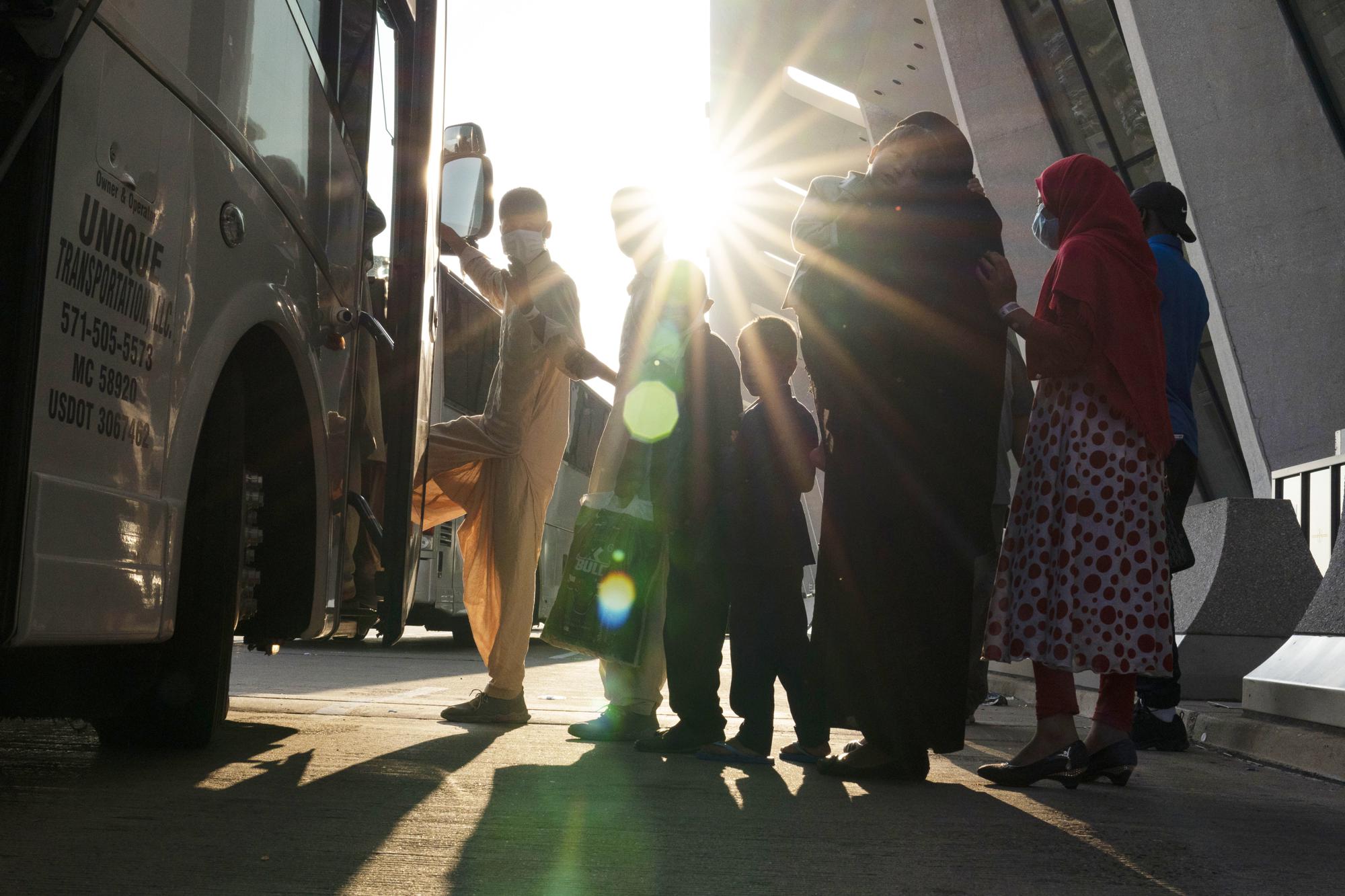 FILE - Families evacuated from Kabul, Afghanistan, wait to board a bus after they arrived at Washington Dulles International Airport, in Chantilly, Va., on Friday, Aug. 27, 2021. In late summer 2021, the Taliban seized power in Afghanistan. (AP Photo/Jose Luis Magana, File)
