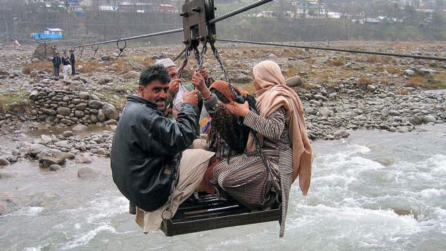 Pakistani's sit on a makeshift cable car to cross a river to get to their home in 2007