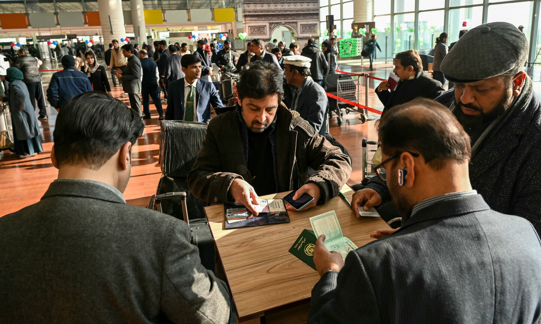 Immigration officers check documents of passengers before boarding their Pakistan International Airlines (PIA) flight to Paris at the Islamabad International Airport on Jan 10, 2025. — AFP