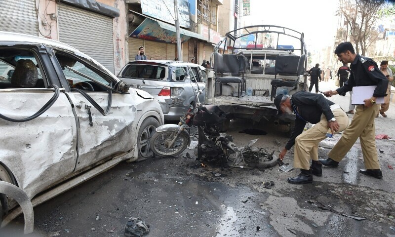 <p>Police officials examine the site of a bomb blast in Quetta on April 10. — AFP</p>