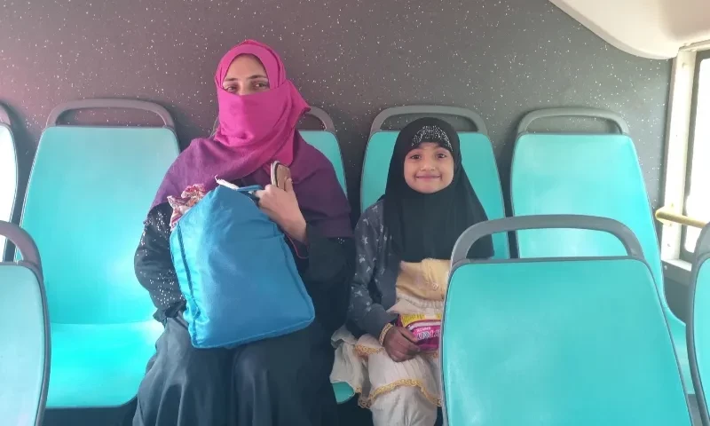  Ten-year-old Safia and her mother consider themselves lucky to have gotten seats on a bus in Karachi. — Photo by author 
