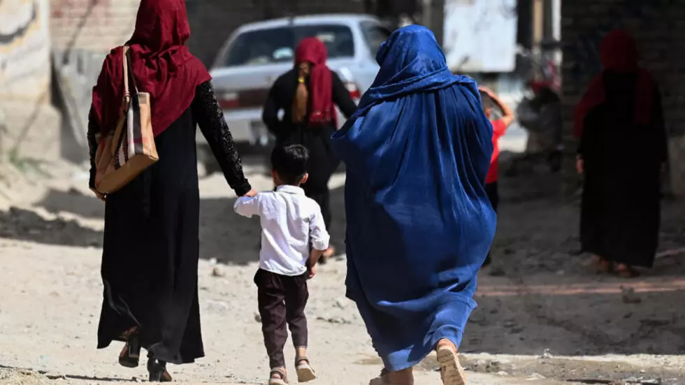 A child is accompanied by elders as they walk along an alley in Kabul, Afghanistan on July 24, 2021.