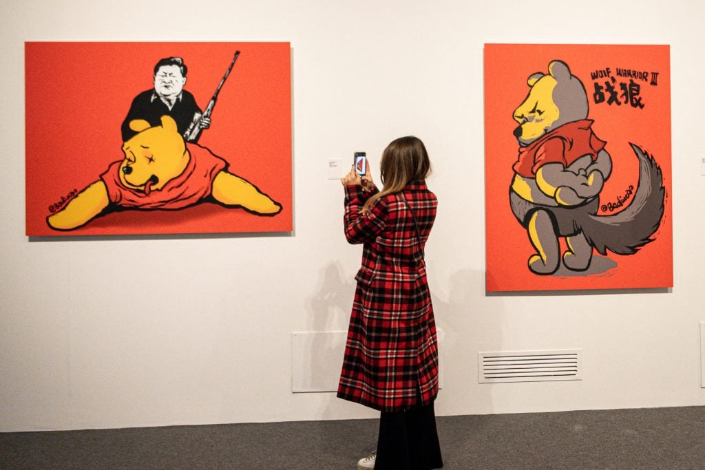 A visitor takes photos of Winnie the Trophies, 2017, an artwork by Chinese dissident artist Badiucao at the Santa Giulia museum in Brescia, Lombardy. Photo by Piero Cruciatti/AFP via Getty Images.