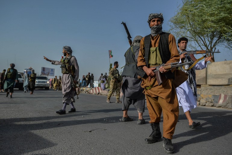 Afghan security personnel and Afghan militia fighting against Taliban, stand guard in Enjil district of Herat province [File: Hoshang Hashimi/AFP]