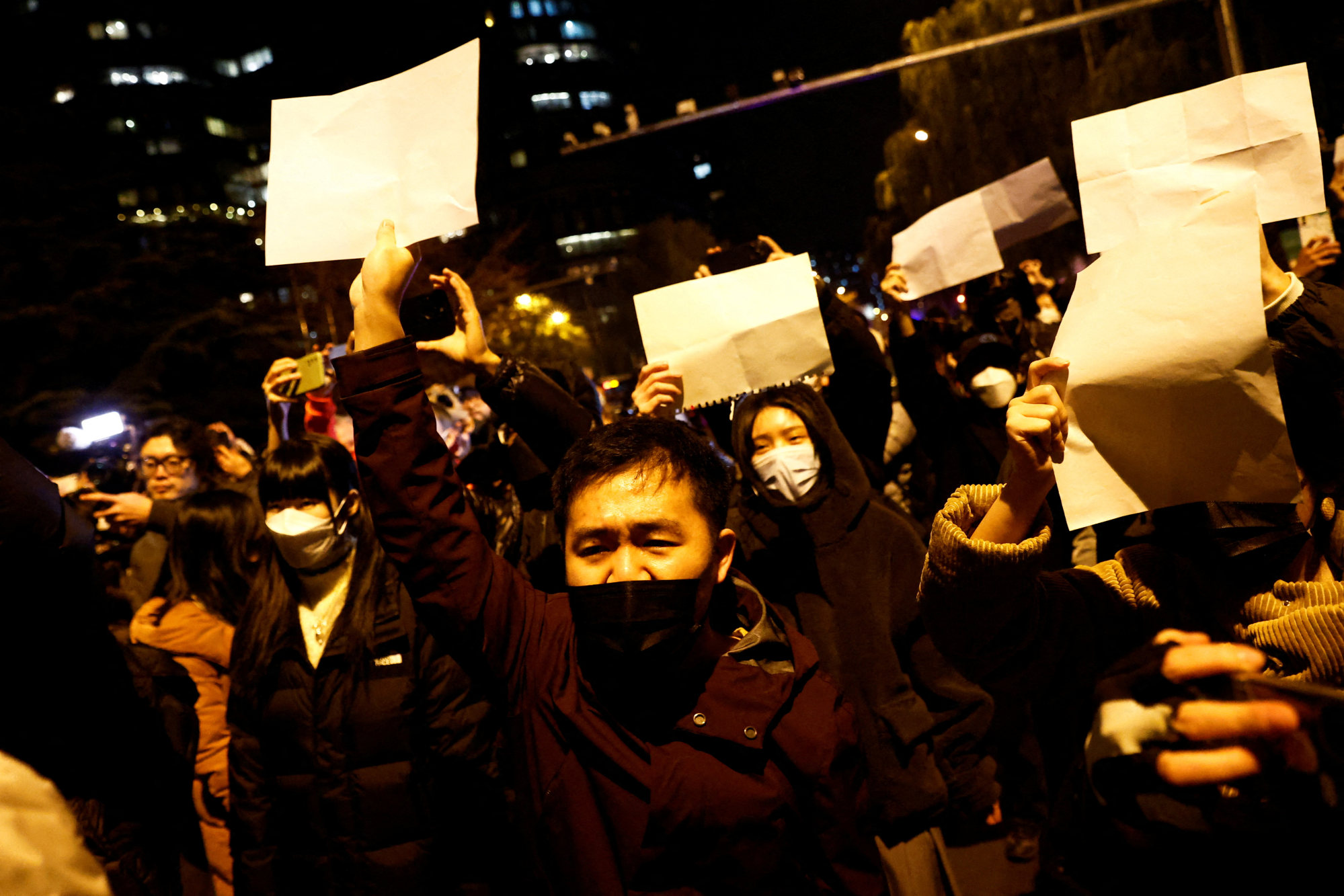 Protesters hold up blank sheets of paper in Beijing. Photo: Reuters