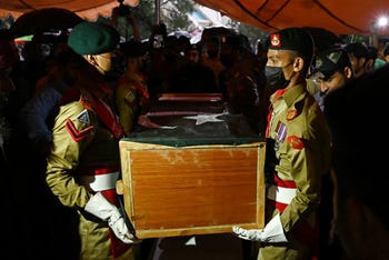 Soldiers carry the flag-drapped coffin of the late Pakistan's nuclear scientist Abdul Qadeer Khan during his funeral outside the Faisal Mosque following his death in Islamabad this week
