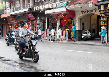 teenage-boy-riding-electric-scooter-motorbike-through-hanoi-city-centre-f4fg15.jpg