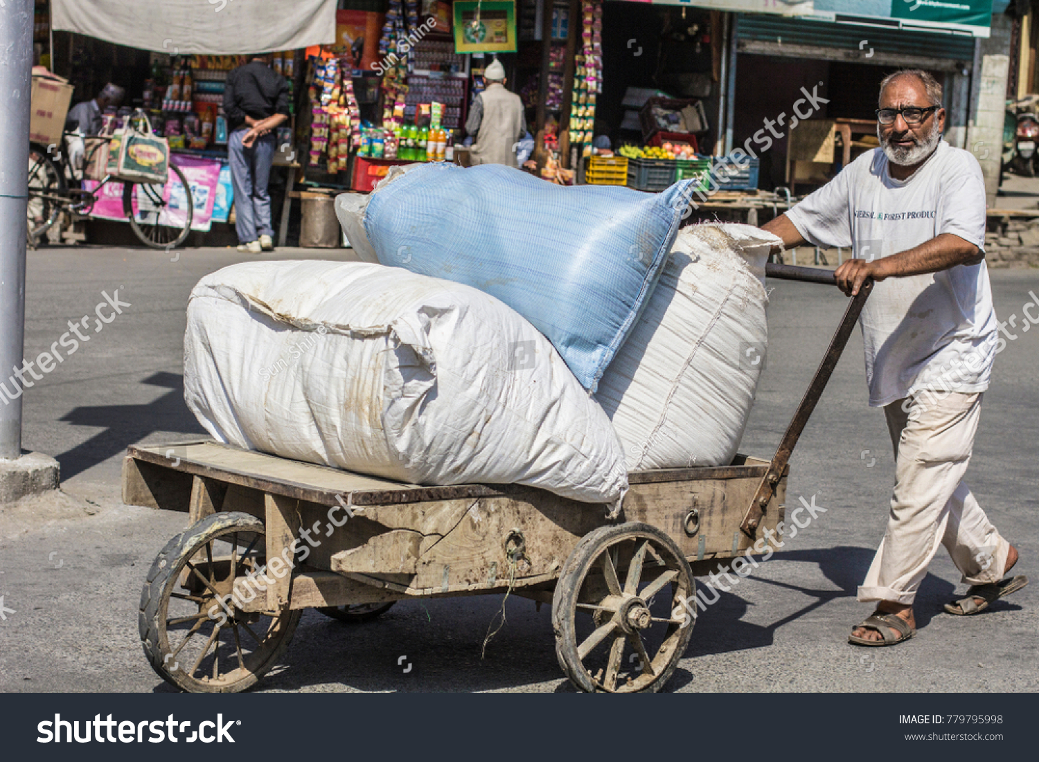 stock-photo-kashmir-october-old-town-in-srinagar-kashmir-indian-man-at-work-pushing-cart-to-the-779795998.jpg