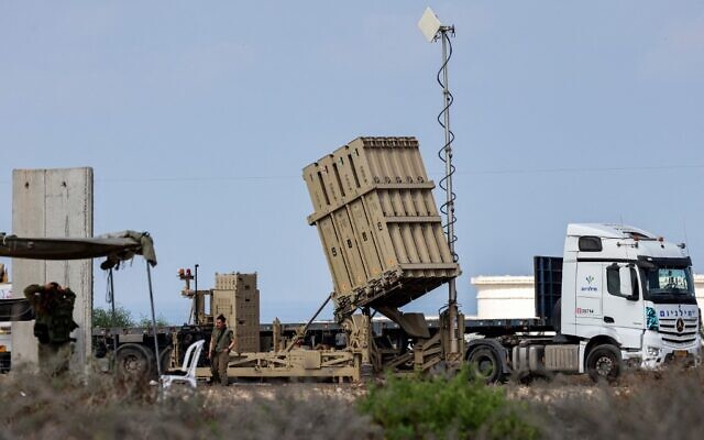 Illustrative: Israeli soldiers stand near a battery of the Iron Dome missile defense system in southern Israel on August 6, 2022. (Jack Guez/AFP)