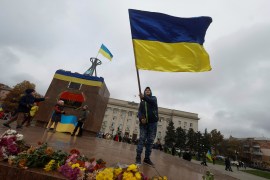 A boy waves the Ukrainian flag as he celebrates after Russia's retreat from Kherson, in central Kherson on November 13, 2022 [Reuters/Valentyn Ogirenko]