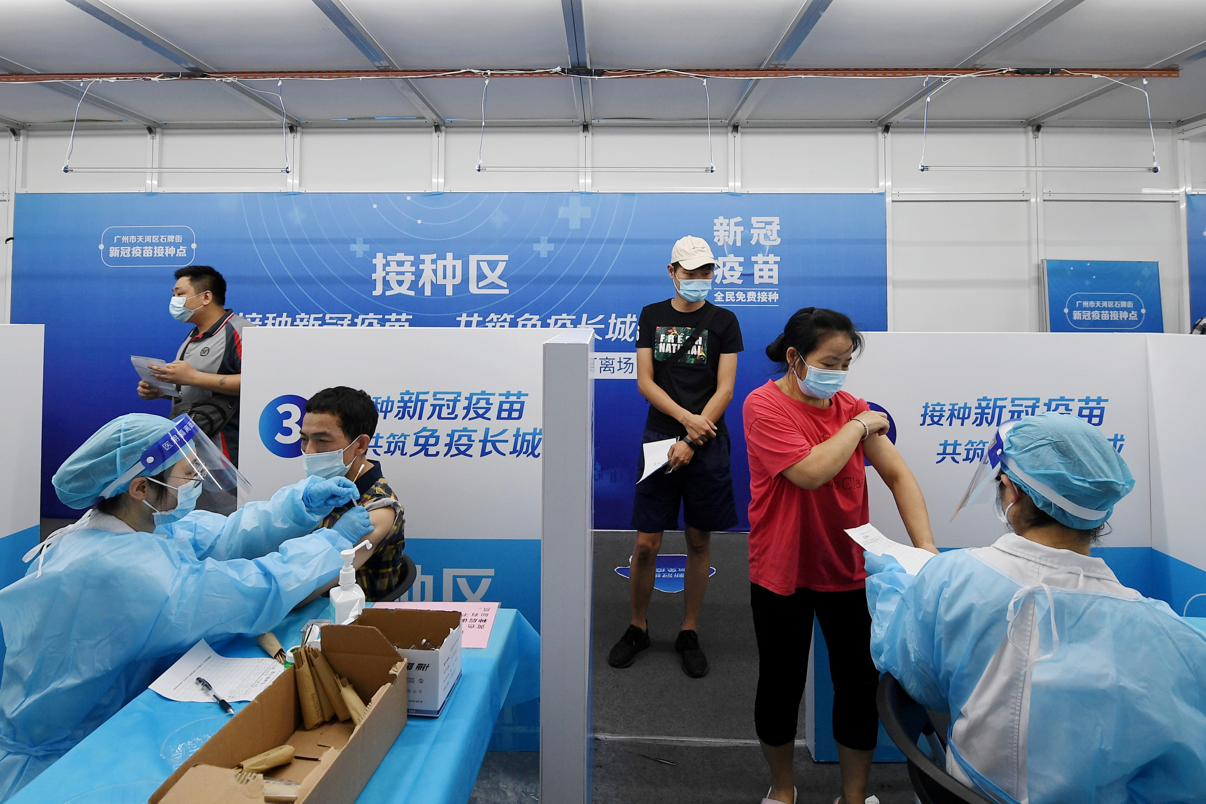 Residents receive vaccines against the coronavirus disease (COVID-19) at a makeshift vaccination site in Guangzhou, Guangdong province, China June 21, 2021. Picture taken June 21, 2021. cnsphoto via REUTERS