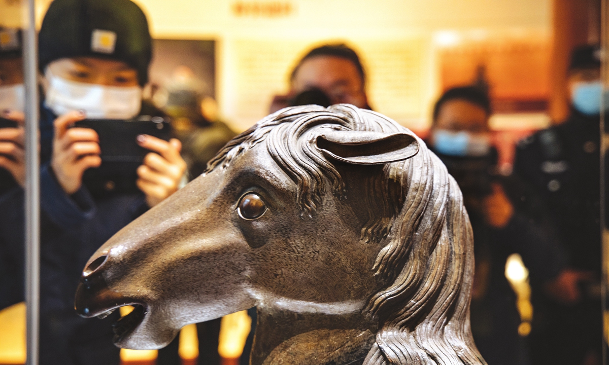 Visitors take pictures of the bronze horse zodiac head that was stolen by invading forces when British and French troops razed the Old Summer Palace in 1860. The statue finally returned to its home, Yuanmingyuan, or the Old Summer Palace, on Tuesday. Photo: Li Hao/GT