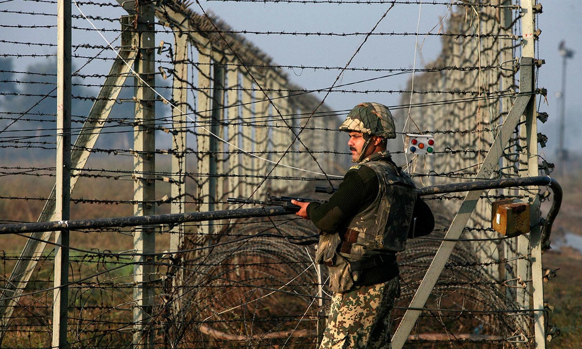 An Indian Border Security Force soldier patrols the fenced border with Pakistan in Suchetgarh, located southwest of Jammu and Kashmir. Credit: Reuters