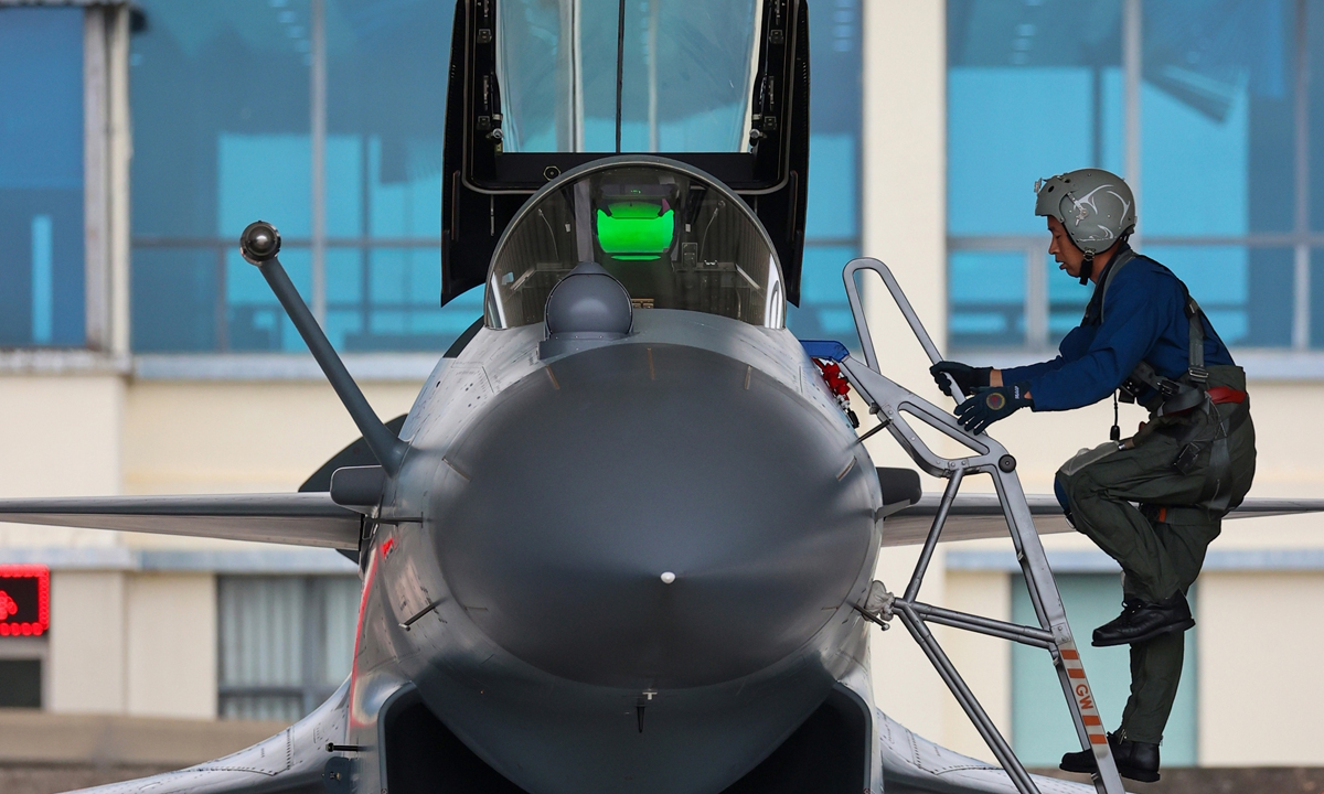 A pilot assigned to an aviation brigade of the air force under the PLA Southern Theater Command climbs into the cockpit of his J-10 fighter jet during a flight training exercise on October 11, 2021.Photo:China Military