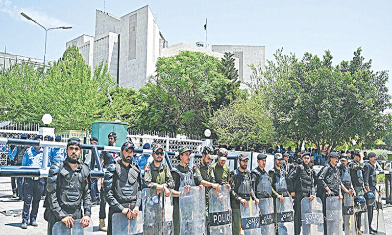  Security personnel standing guard as PDM supporters gather near the Supreme Court to protest against the judiciary’s alleged facilitation of Imran Khan | AFP 