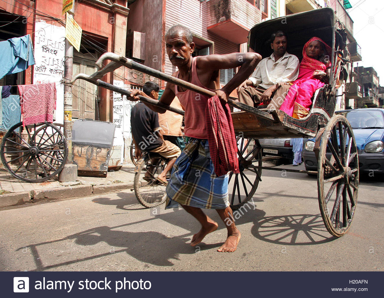 an-indian-hand-pulled-rickshaw-puller-runs-with-passenger-in-the-eastern-H20AFN.jpg