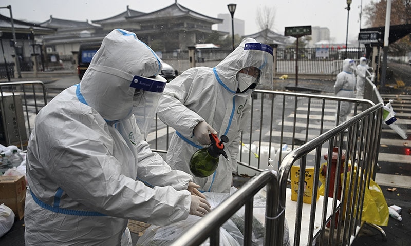 In this photo released by Xinhua News Agency, workers wearing protective suits disinfect packed vegetables at a residential area under quarantine in Xi'an in northwestern China's Shaanxi Province. — AP