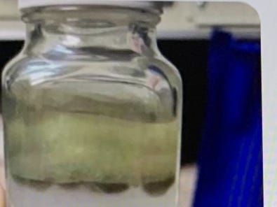 A screenshot of a text exchange with a photo of a sample of what was identified as water from the USS Nimitz contaminated with jet fuel.