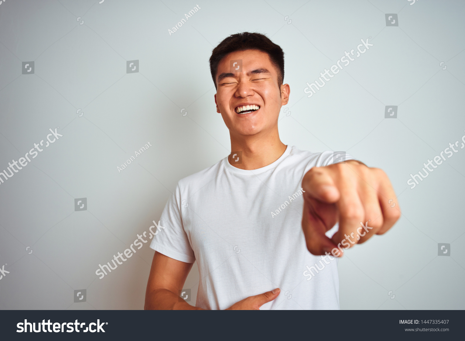 stock-photo-young-asian-chinese-man-wearing-t-shirt-standing-over-isolated-white-background-laughing-at-you-1447335407.jpg