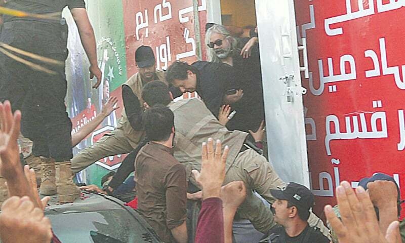 PTI workers and his private bodyguards help Imran Khan out of the container following the attack in Wazirabad on Nov 3. —Aun Jafri