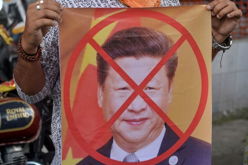 Bharatiya Janata Party activists hold a sign showing an X over the face of Chinese President Xi Jinping during an anti-China protest in Siliguri, India, on June 17.