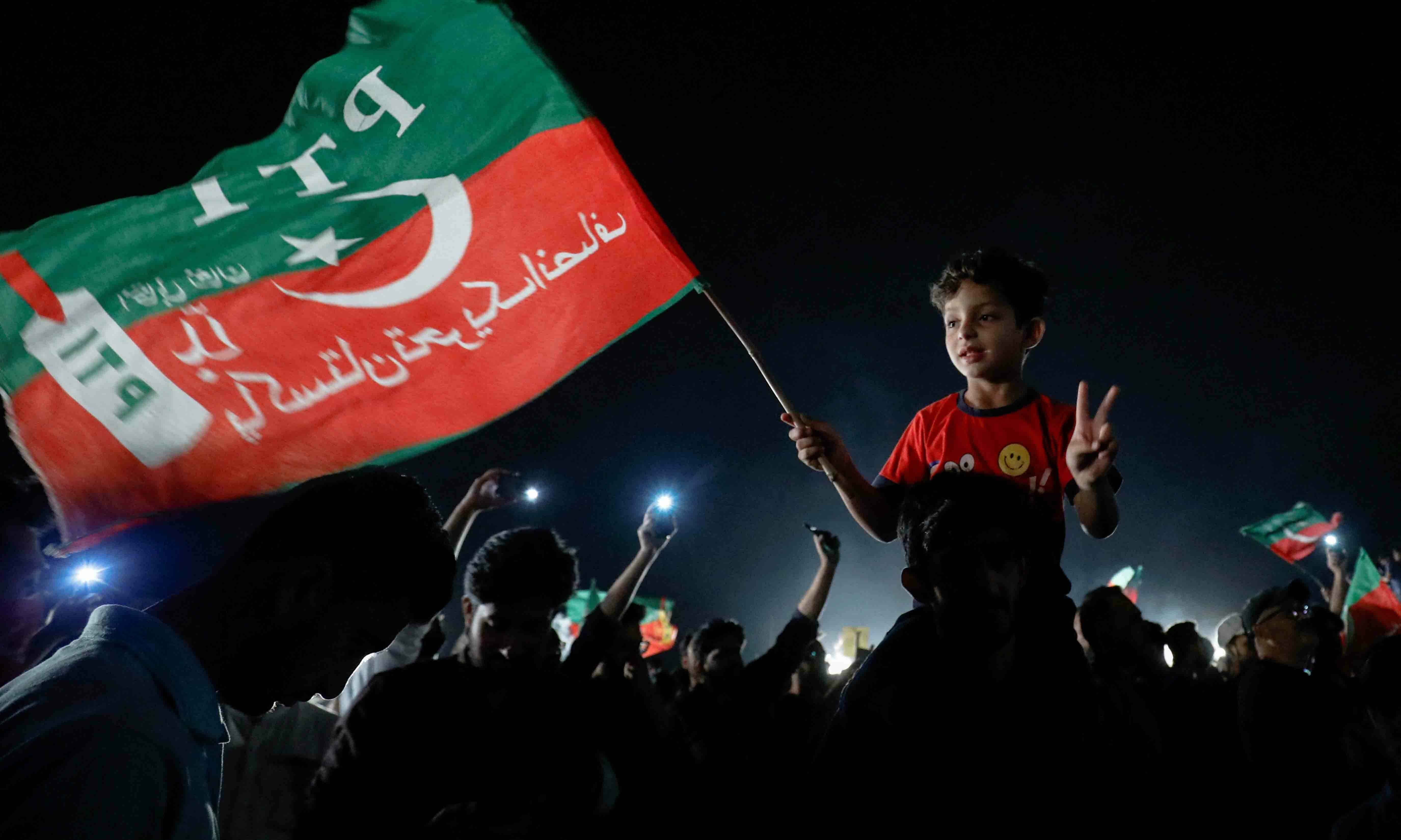 A child waves a PTI flag and gestures during a rally in support of former prime minister Imran Khan in Islamabad on April 10. — Reuters
