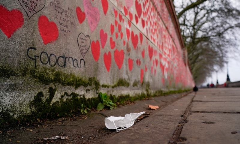 A face mask lies on the ground, next to the Covid Memorial Wall, in London, on January 15. — AP