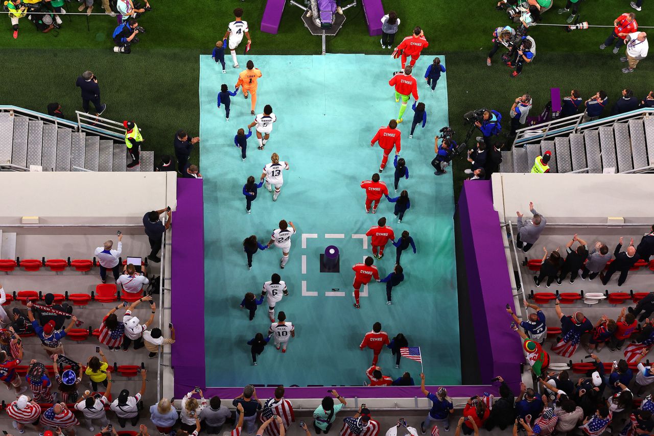 Welsh and American players walk onto the field Monday.