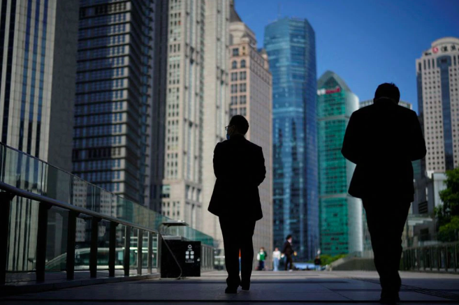 people walk by office towers in the lujiazui financial district of shanghai china october 17 2022 photo reuters aly song file photo