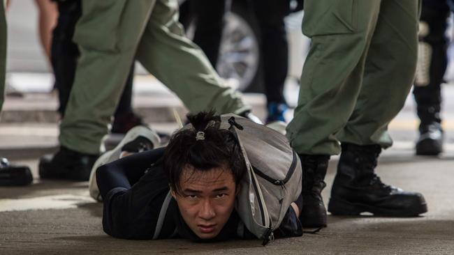 Riot police detain a man as they clear protesters taking part in a rally against a new national security law in Hong Kong on July 1. Picture: DALE DE LA REY / AFP.