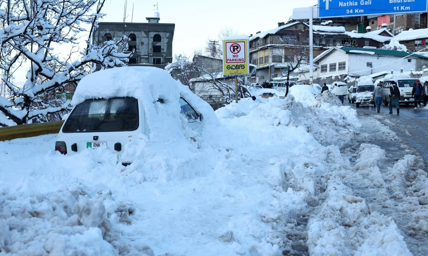 A vehicle is pictured after getting stuck in snow along a road after a heavy snowfall in Murree on January 8. — AFP