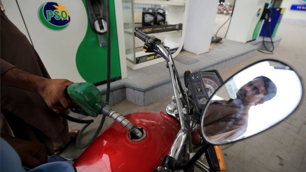 A fuel station attendant fills the tank of a motorcycle in Peshawar, Pakistan, 01 July 2022.