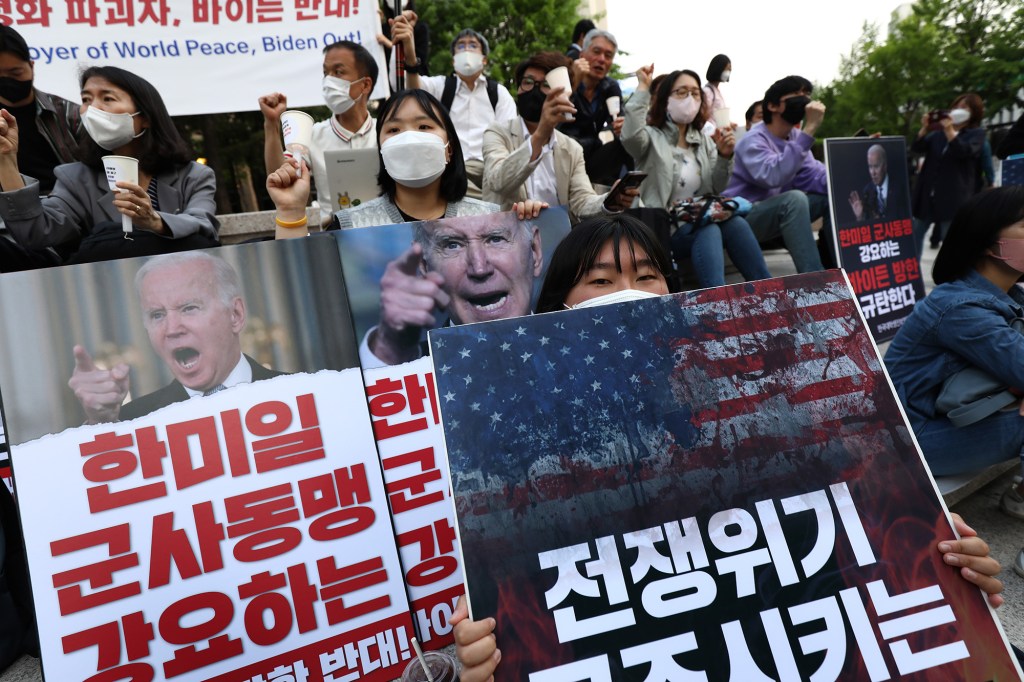 Protesters hold placards at an anti-U.S. rally in Seoul on Friday.