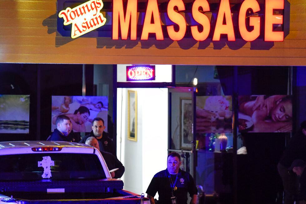 Authorities investigate a fatal shooting at a massage parlor, late Tuesday, March 16, 2021, in...