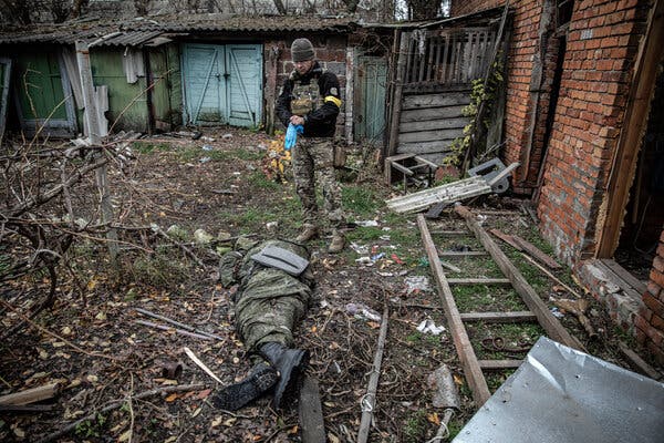 A Ukrainian soldier preparing to remove the body of a Russian soldier this month in Kupiansk-Vuzlovyi, in the Kharkiv region. Russia and Ukraine have each suffered more than 100,000 casualties since the start of the war.