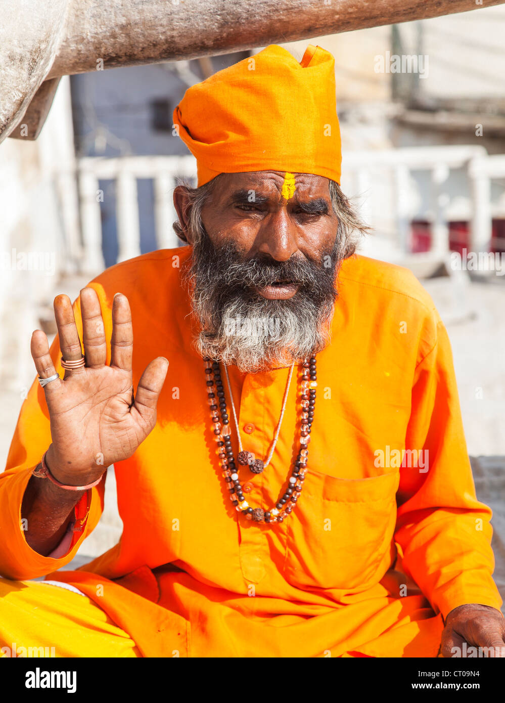 sadhu-indian-hindu-holy-man-dressed-in-traditional-saffron-robes-giving-CT09N4.jpg