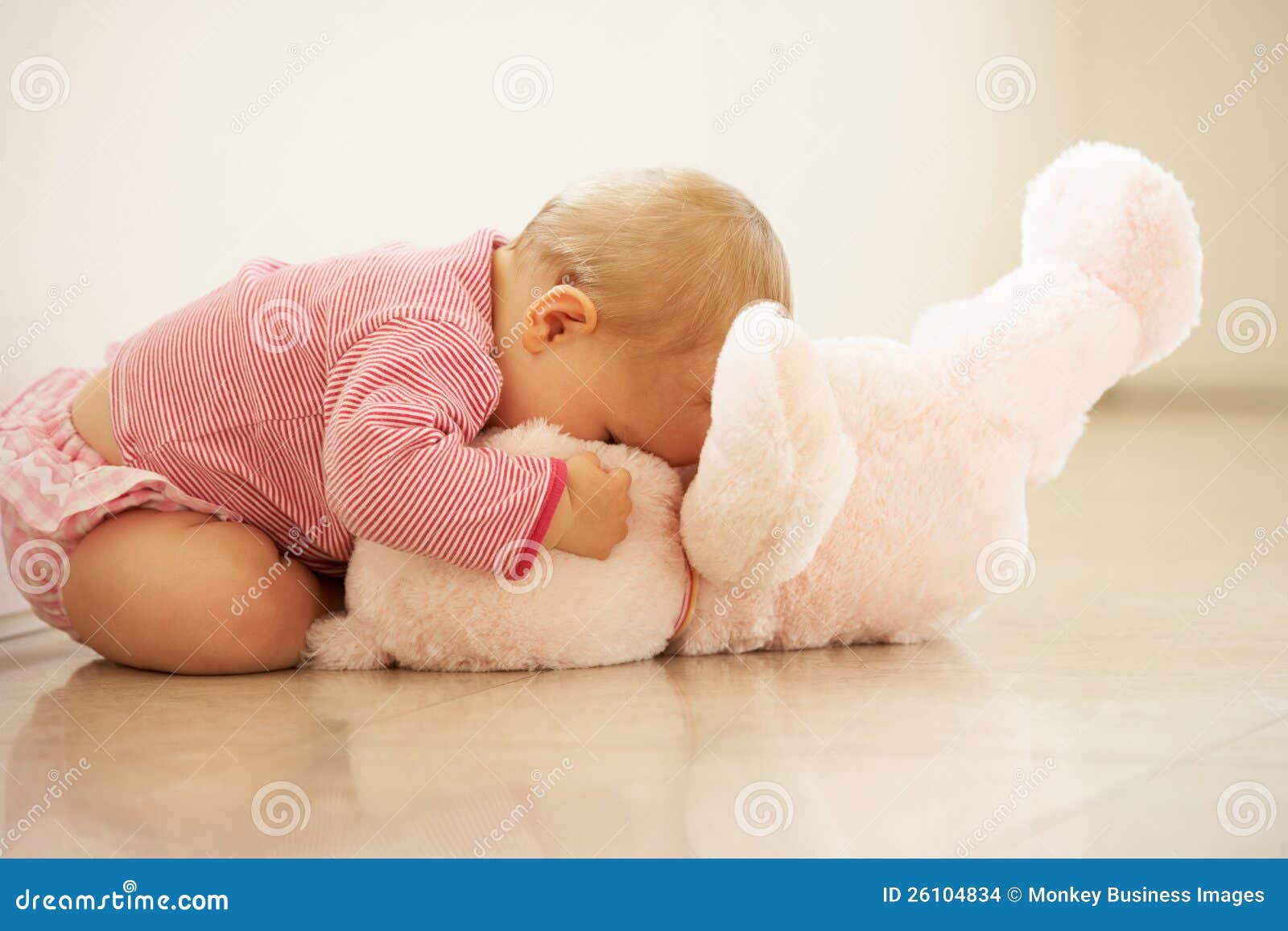 baby-girl-cuddling-pink-teddy-bear-home-26104834.jpg