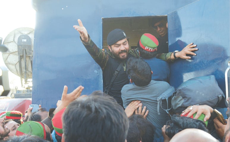 <p>PESHAWAR: PTI workers try to force their way into a prison van outside Central Jail.—Shahbaz Butt / White Star</p>