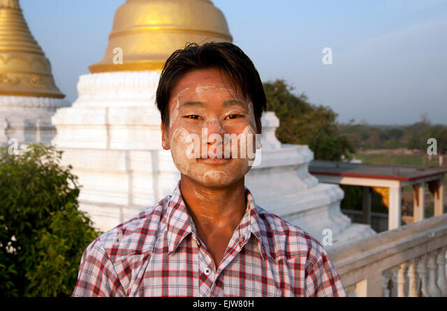 a-young-burmese-man-with-thanaka-bark-smeared-on-his-face-stands-in-ejw80h.jpg