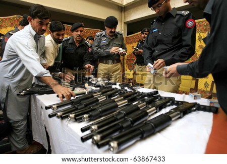 stock-photo-peshawar-pakistan-oct-police-officials-inspect-seized-weapons-and-bullets-during-press-63867433.jpg
