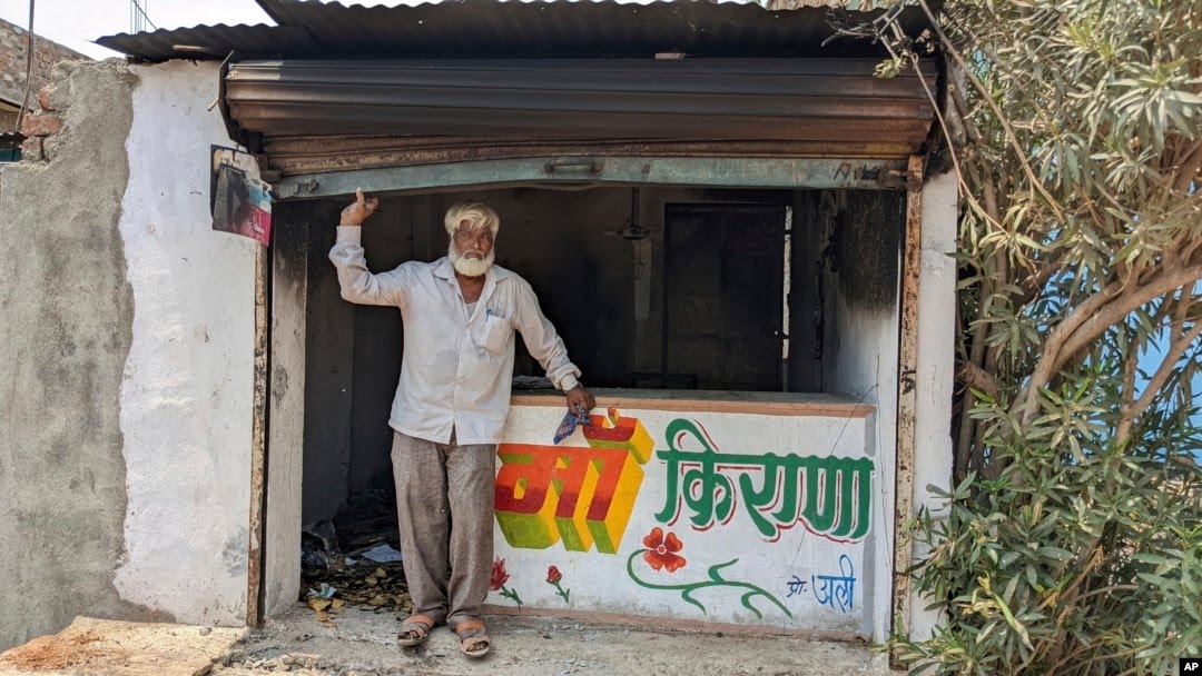 FILE - Nawab Khan stands by the entrance of his shop vandalized by a mob on April 10 in Khargone, in the central Indian state of Madhya Pradesh, April 12, 2022.