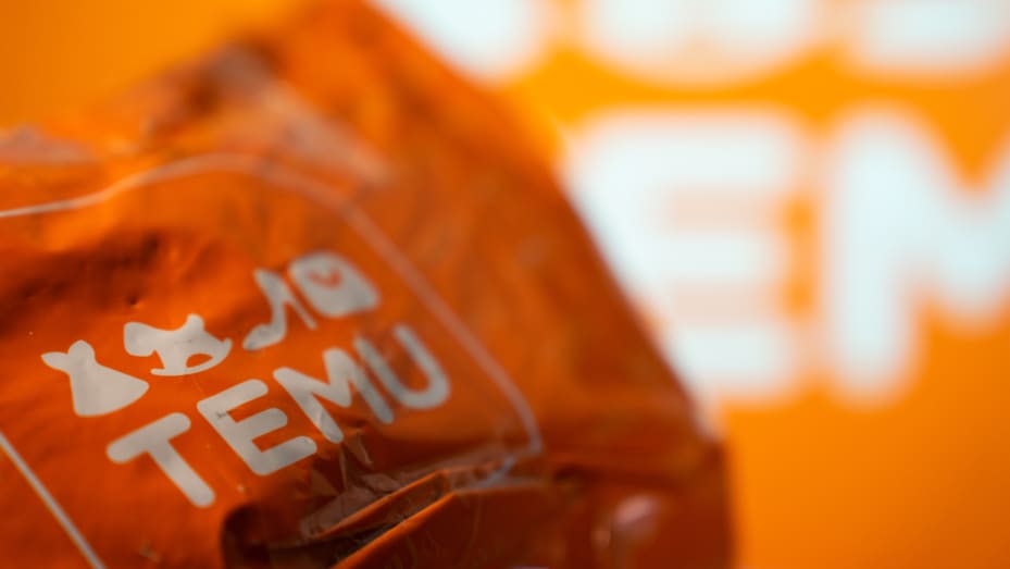 A package from Temu is seen in front of a screen with the Temu logo. (Photo by Nikos Pekiaridis/NurPhoto via Getty Images)