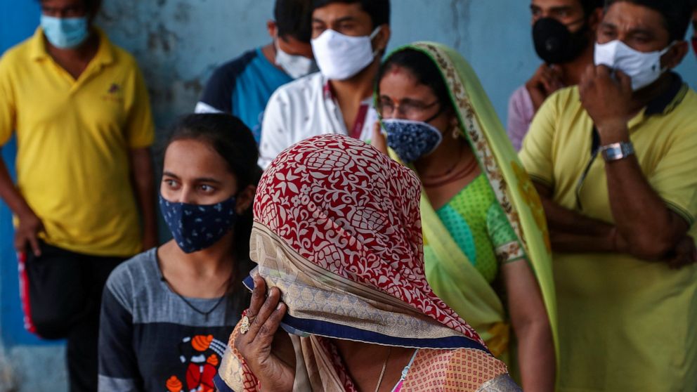 FILE- In this April 19, 2021, file photo, people wearing masks as a precaution against the coronavirus wait to test for COVID-19 at a hospital in Hyderabad, India. Misinformation about the coronavirus is surging in India as the death toll from COVID-