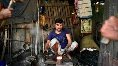 A blacksmith forges iron on an anvil in Dhaka. Bangladesh’s record of both human development and economic growth so far has been truly impressive. AFP