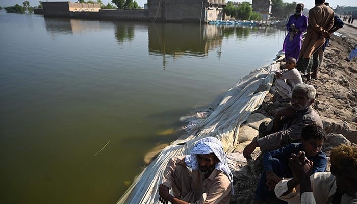 Flood-affected people gather by an embankment in Mehar city after heavy monsoon rains in Dadu district, Sindh province on September 9, 2022. — AFP/File