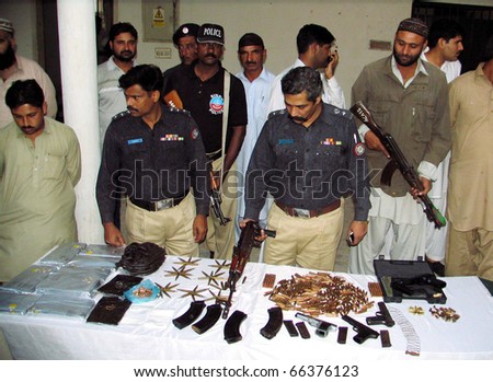 stock-photo-karachi-pakistan-dec-police-officials-look-at-seized-drugs-weapons-and-bullets-which-were-66376123.jpg